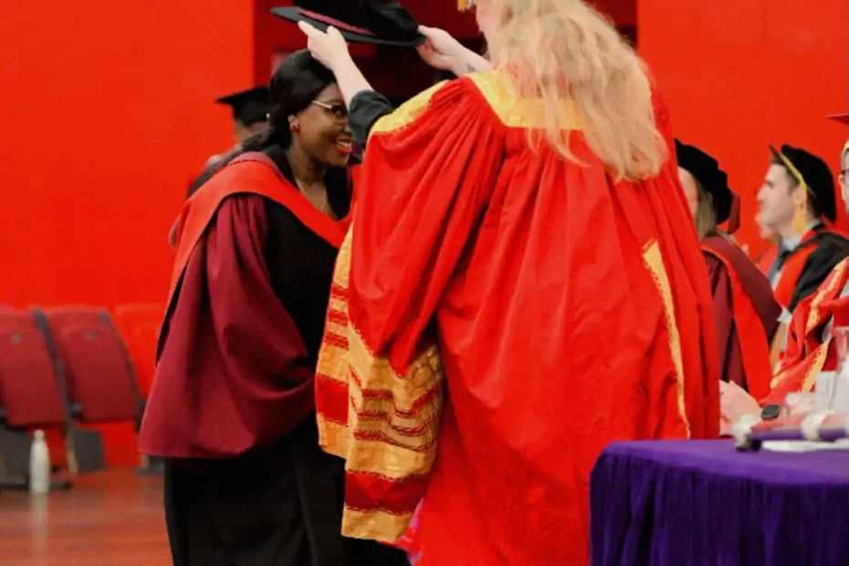 Dr. Alice Maina PhD graduation ceremony at the University of Essex, receiving her doctoral academic cap on stage.